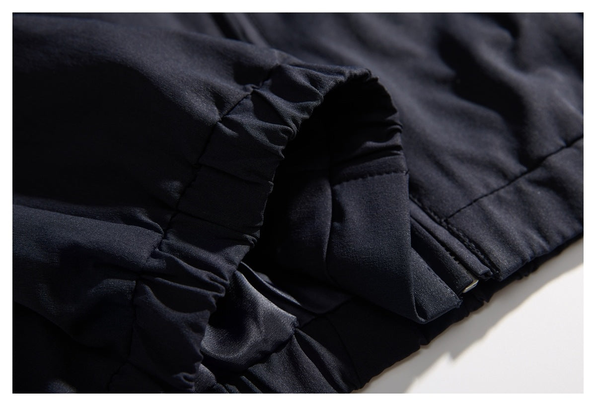 Close-up of gathered black fabric and stitched seams along the garment's edge.