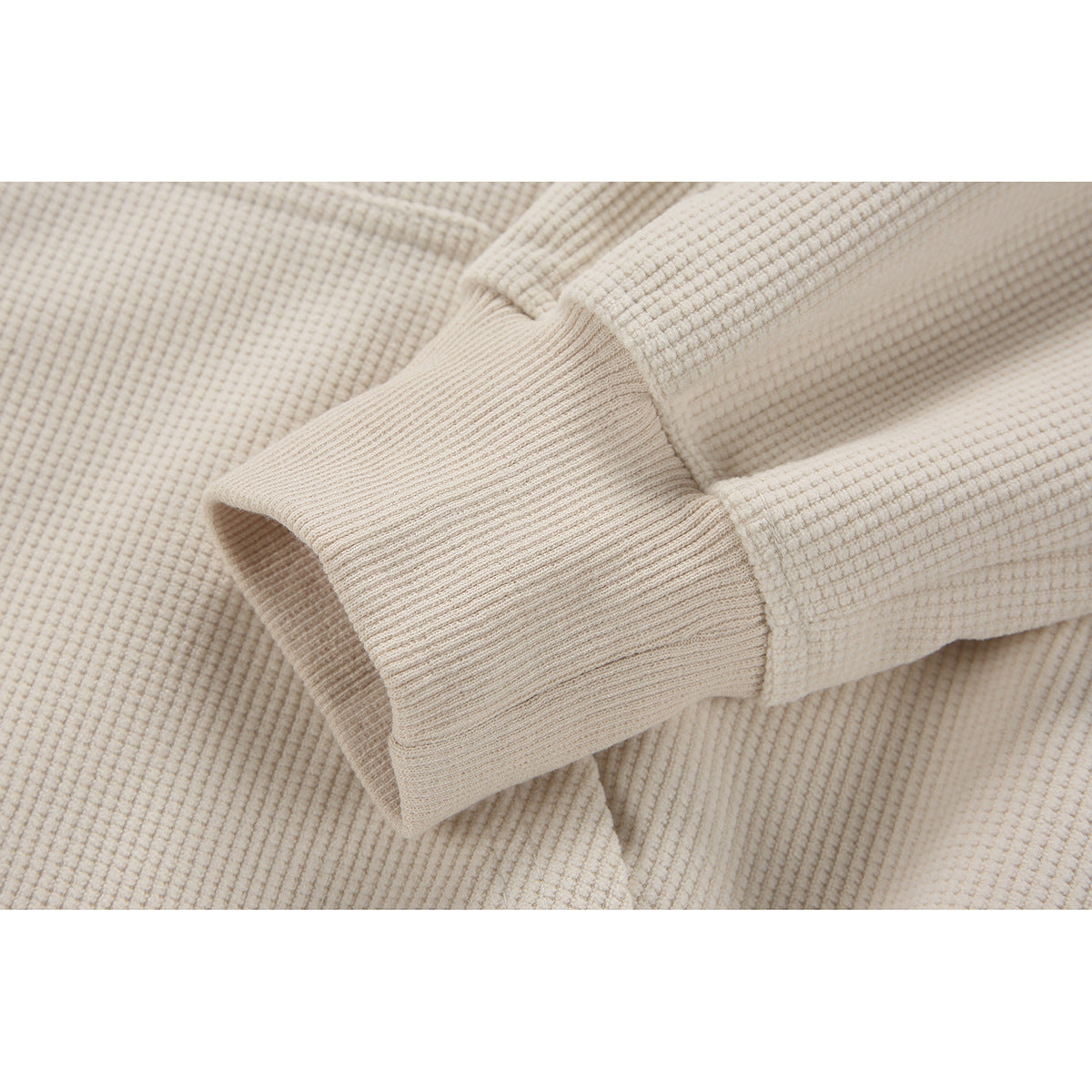 Close-up of a cream textured sleeve and ribbed cuff.