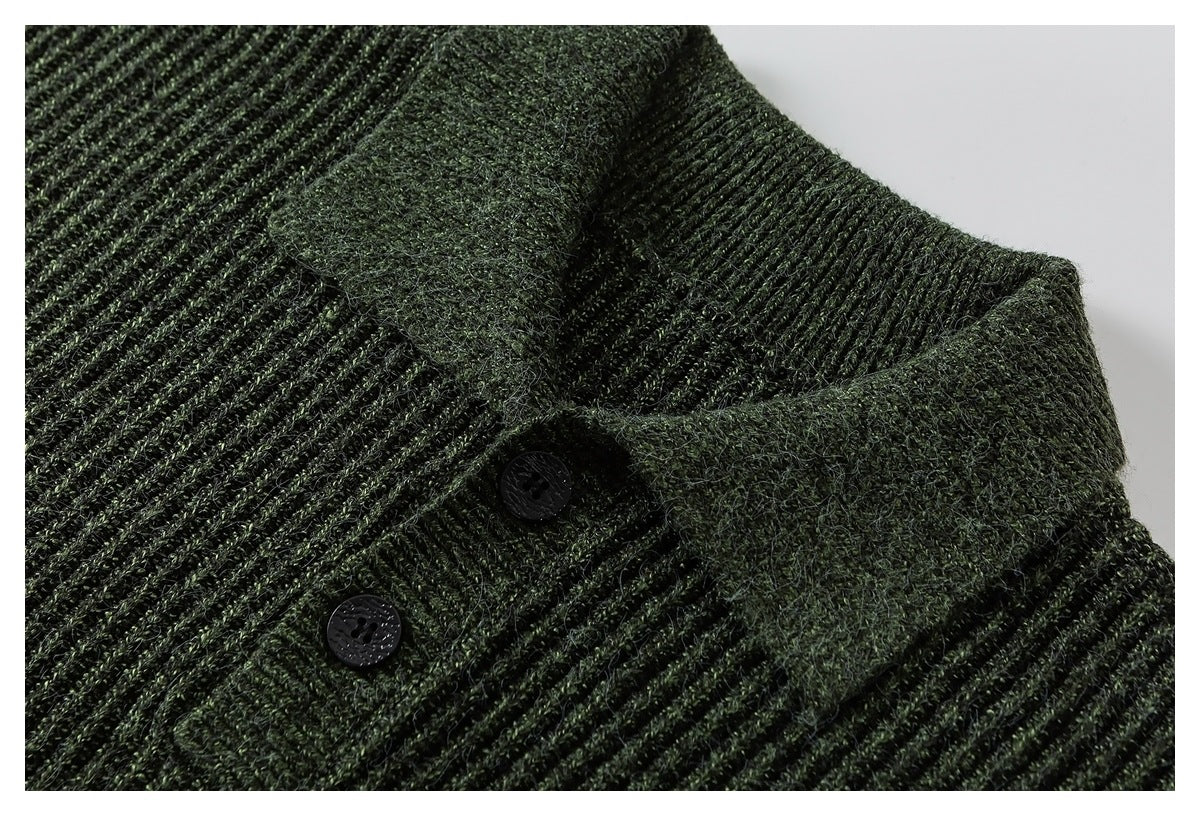 Close-up of a deep green rib-knit garment with a folded edge and two dark buttons.