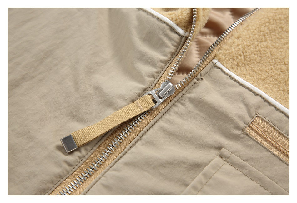 Close-up of the jacket's metal front zipper, tan pull tab, contrasting panels, and white piping.