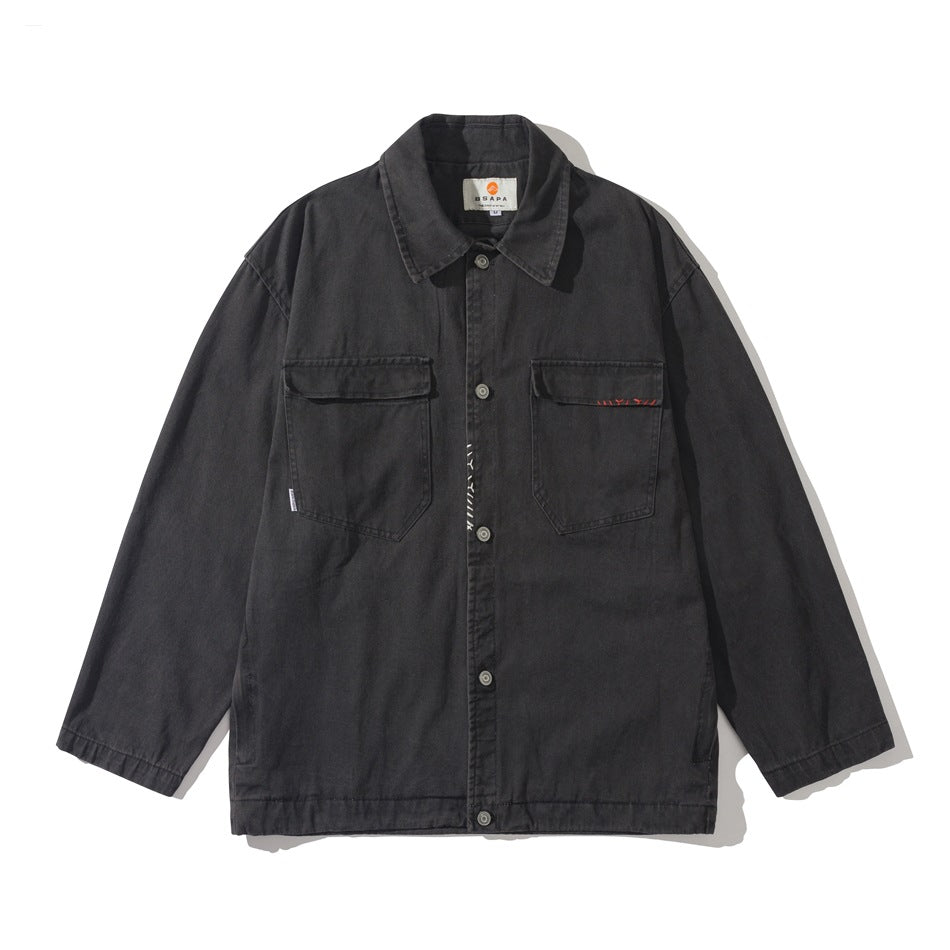 Black washed button-front utility jacket with pointed collar and two chest flap pockets, flat lay front view