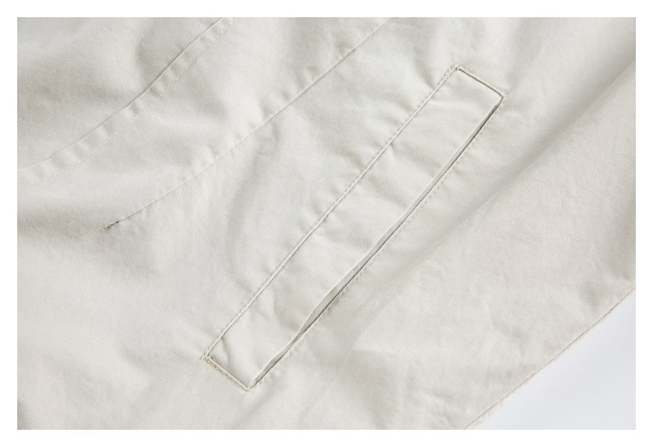 Close-up of a long narrow welt pocket on cream fabric, with visible stitching and seams.