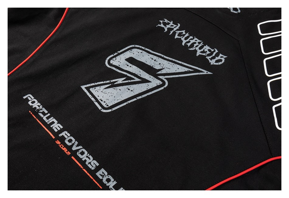Close-up of a black shirt with distressed gray graphics, white lettering, and red piping.