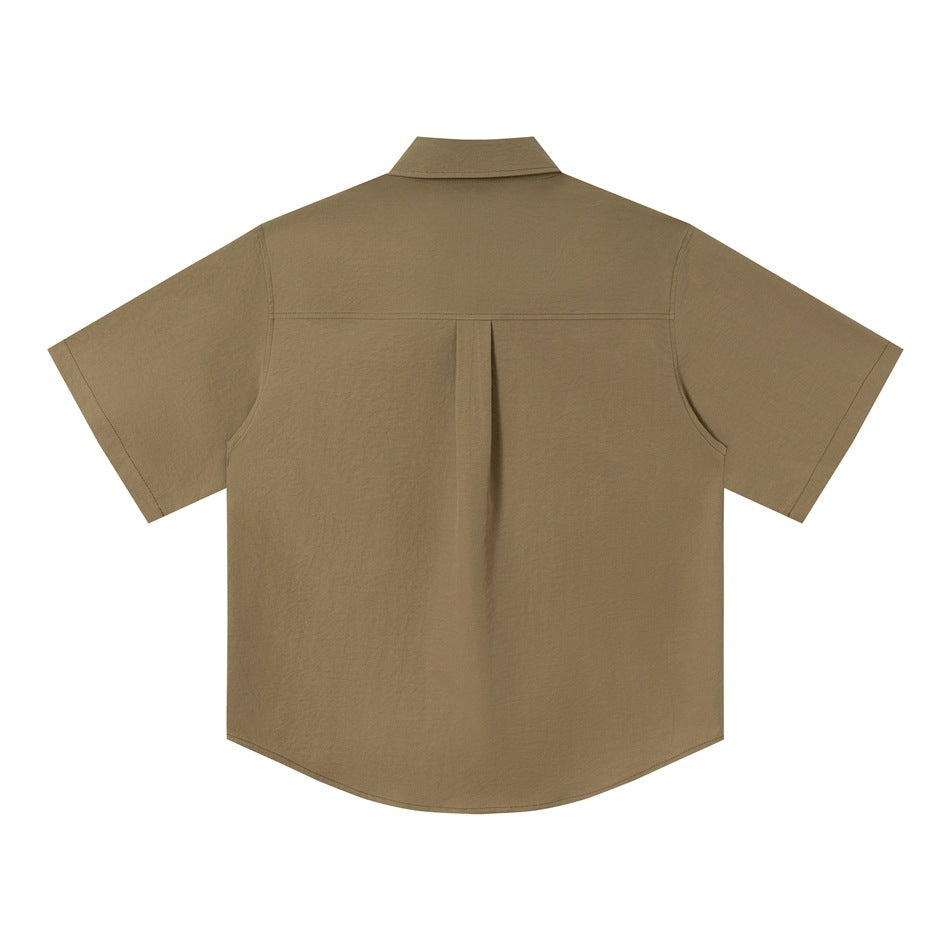Back view of olive-tan green short-sleeve shirt flat lay with yoke seam and center pleat