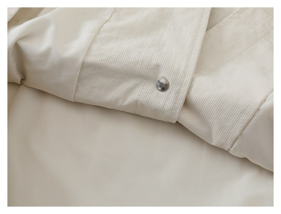 Close-up of an ivory ribbed jacket cuff with a metal snap button and smooth lining.