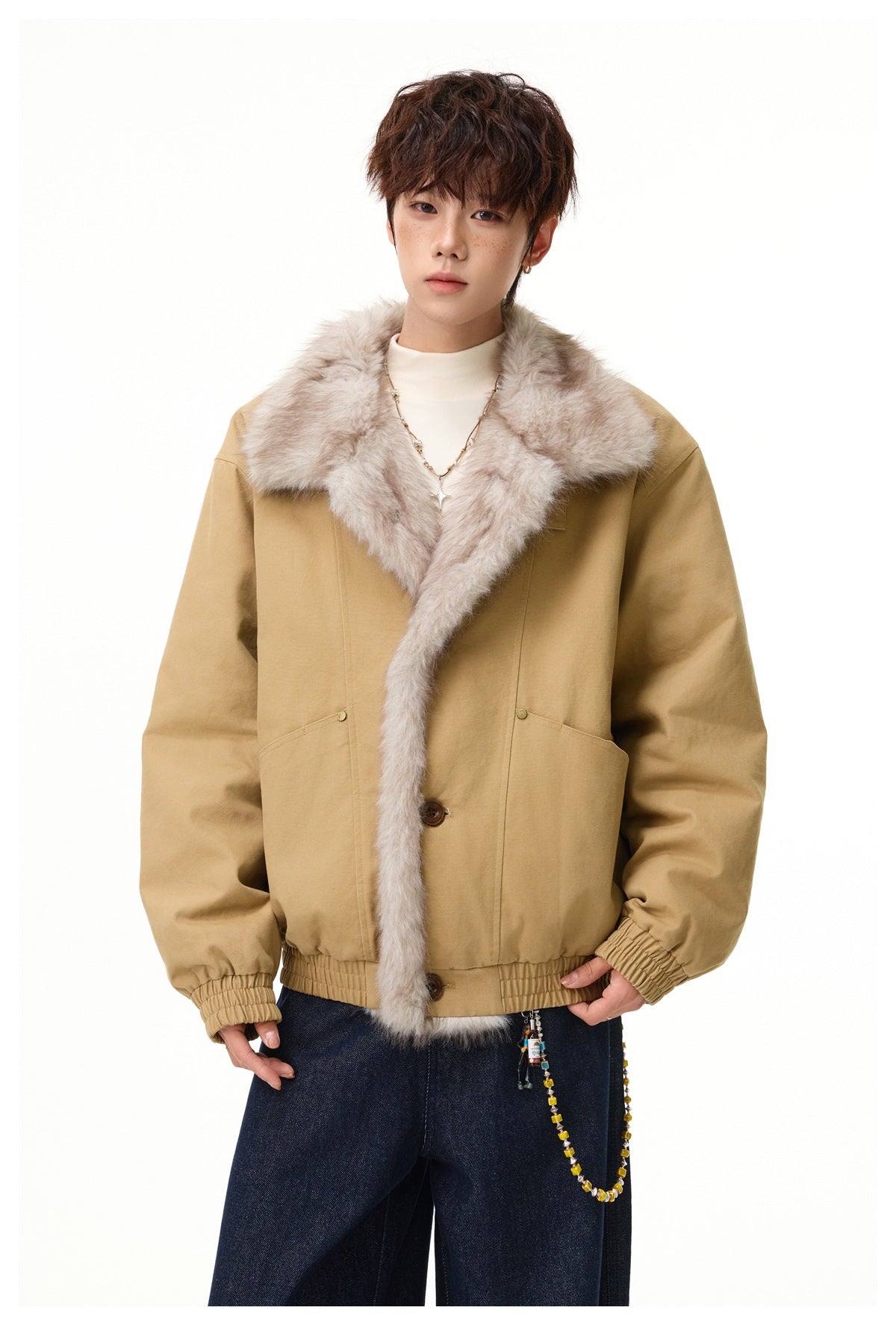 Front view of a model in a tan jacket with a wide pale fur collar and trim, brown buttons, and gathered cuffs and hem.