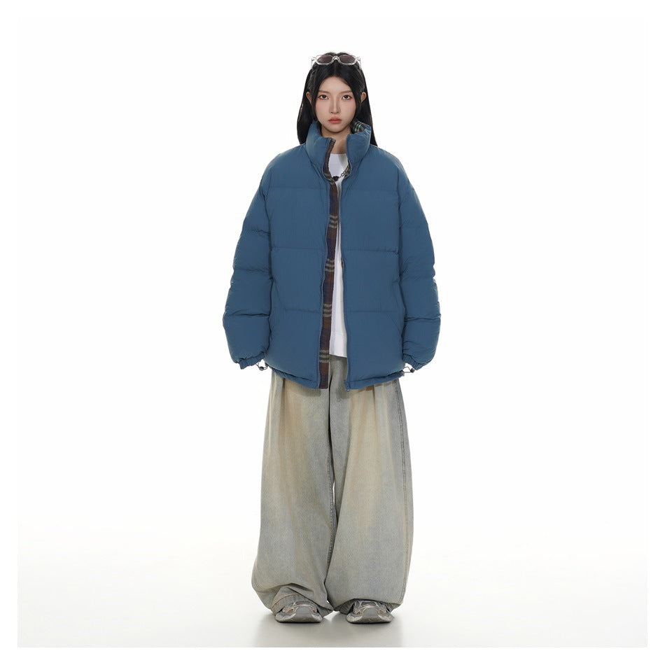 Full-length model wearing a blue quilted puffer jacket with a high collar and wide light-wash jeans.