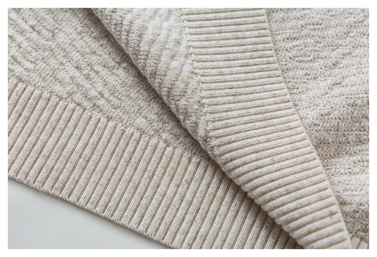 Close-up of the cream knit top's ribbed hem and textured fabric.