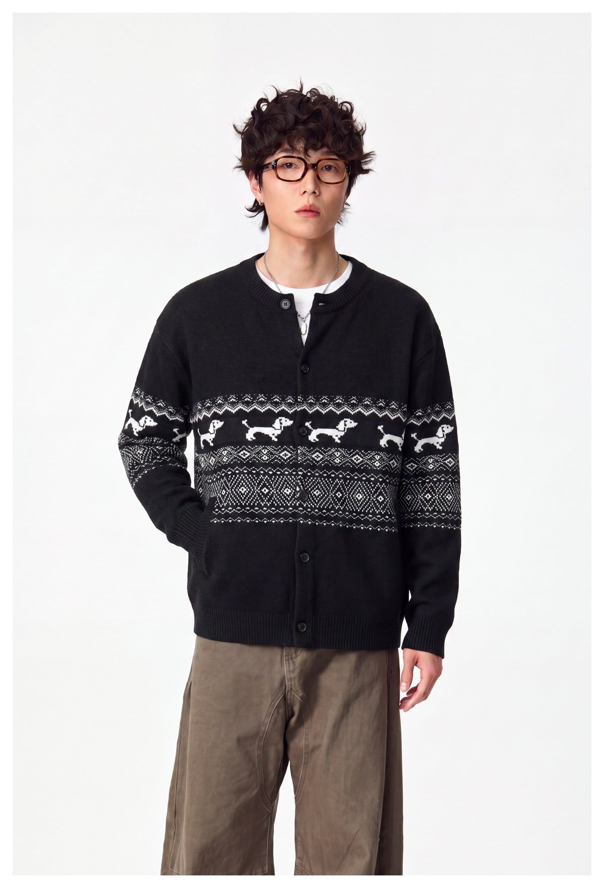 Front view of a model wearing a black button-front cardigan with white dog motifs and geometric patterned bands.