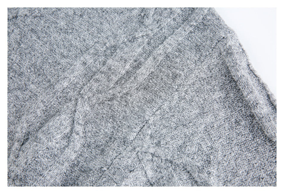 Close-up of gray knit fabric showing a seam and textured stitch pattern.