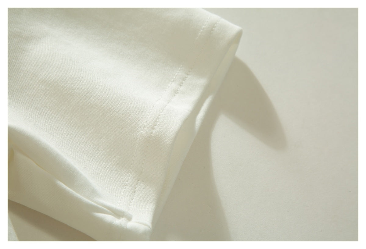 Close-up of the white T-shirt's short sleeve hem and stitching.