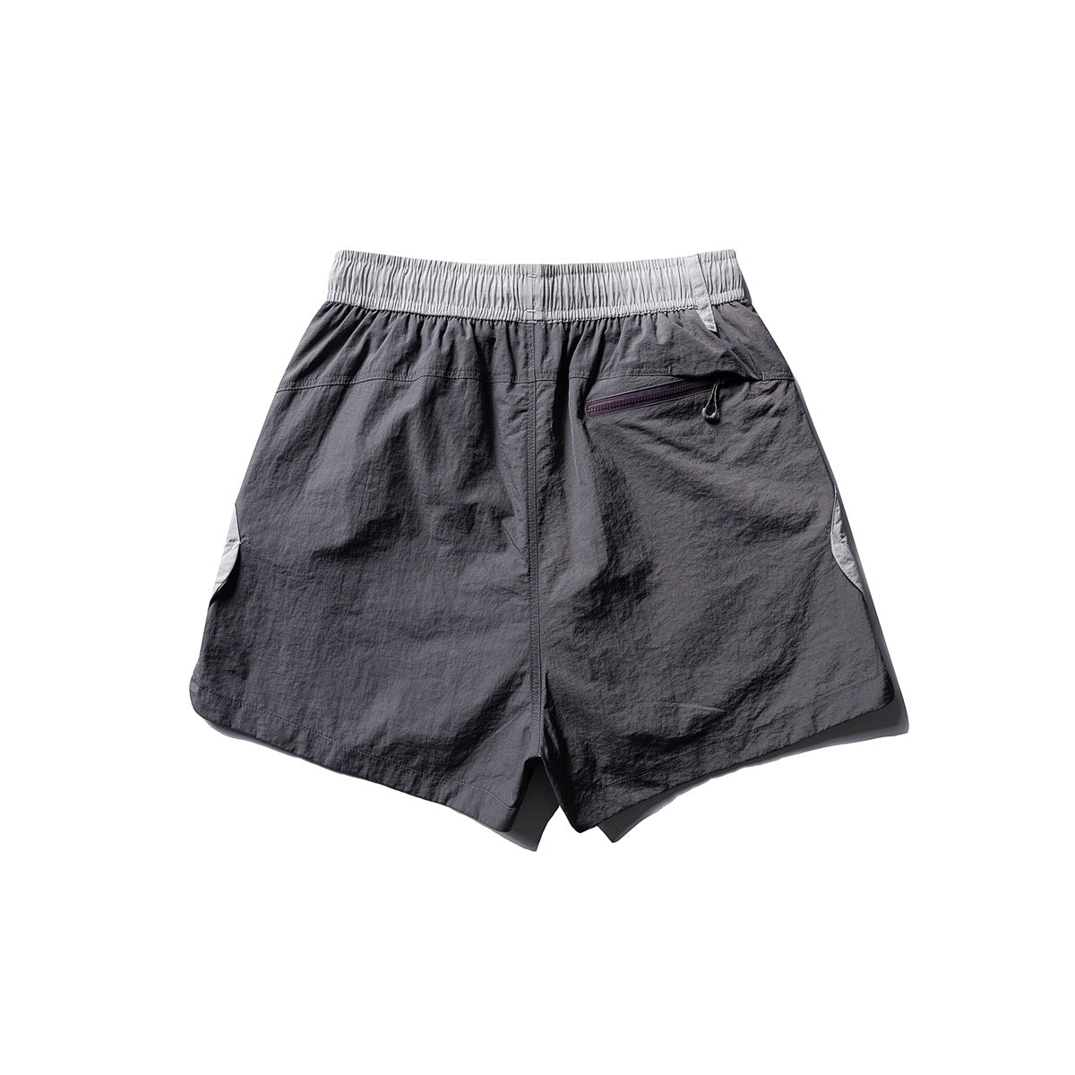 Back view of charcoal athletic shorts with a light gray elastic waistband and an angled zip pocket.
