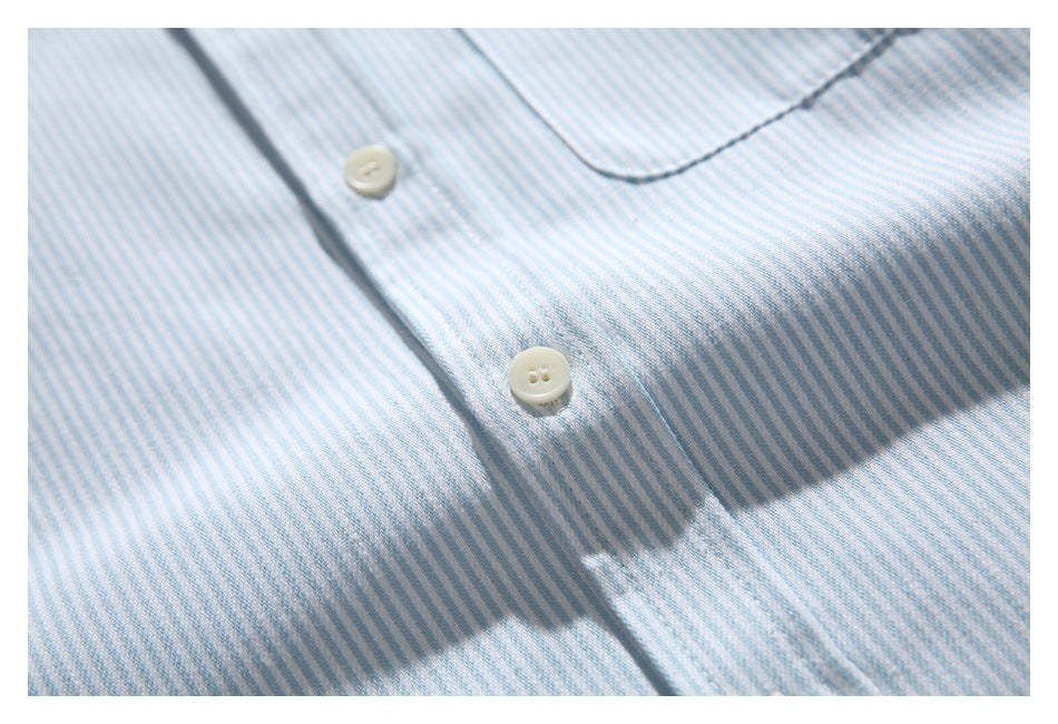 Close-up of a light blue and white striped shirt showing its buttons, placket, and chest pocket.