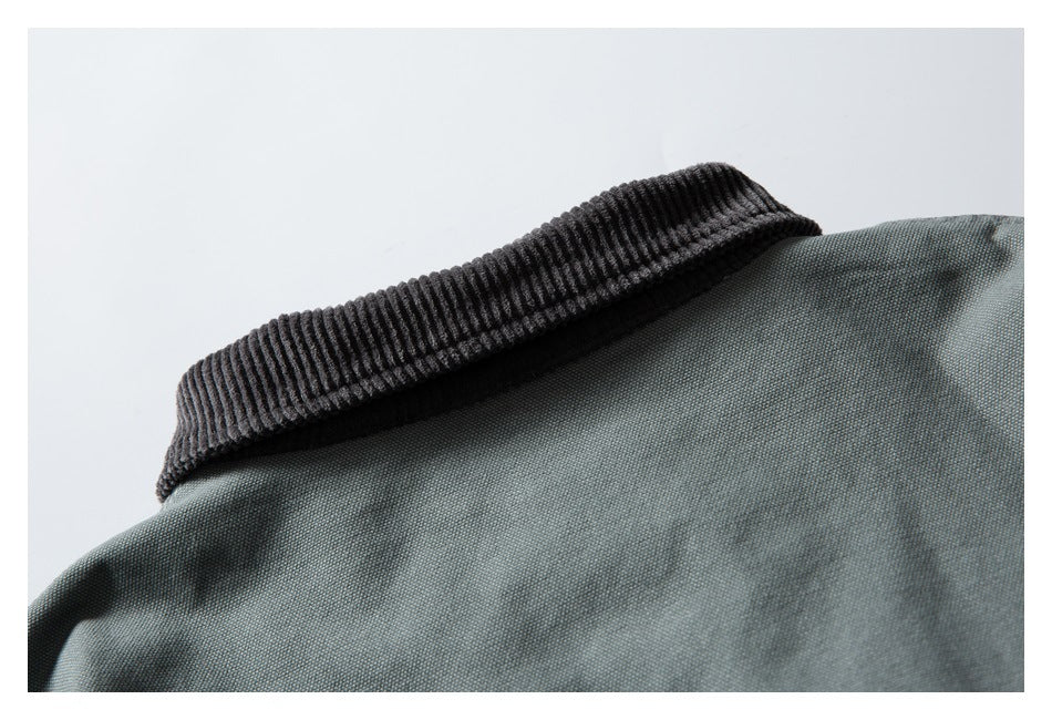 Close-up of a dark ribbed collar on a gray-green garment.