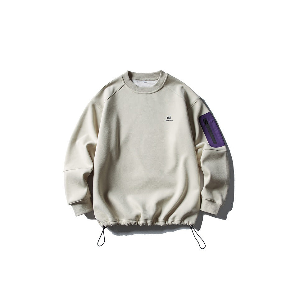 Beige crewneck sweatshirt flat lay with purple zippered sleeve pocket and drawcord hem