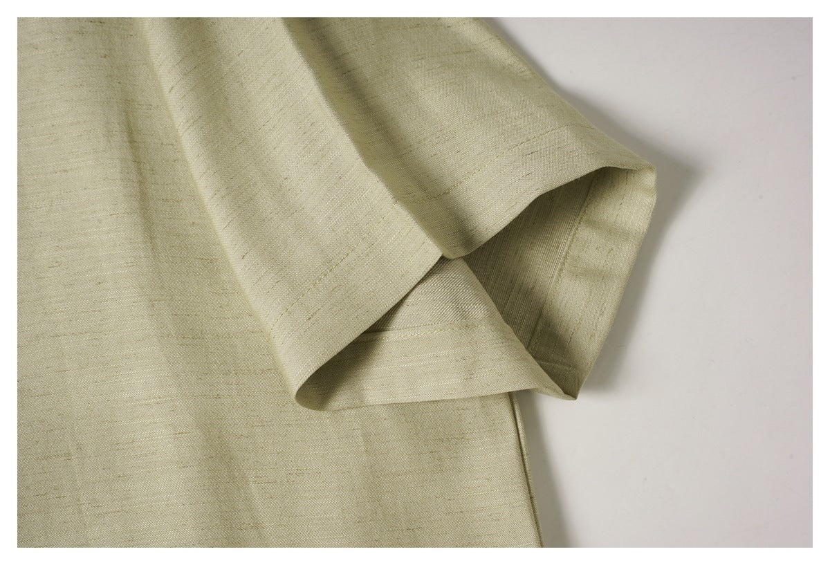 Close-up of a folded, stitched sleeve edge on a pale olive-beige garment.