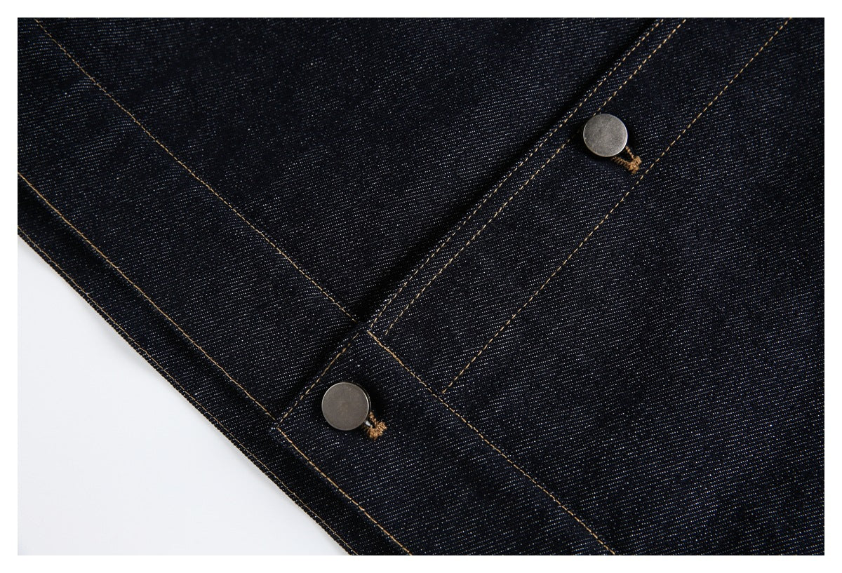 Dark indigo denim close-up showing metal buttons along a stitched placket and intersecting seams.