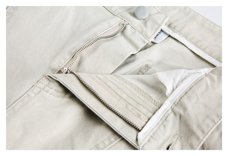 Close-up of the light beige trousers' open zipper fly and inner waistband.