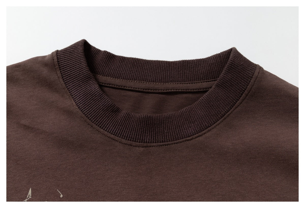 Close-up of a dark brown T-shirt’s ribbed crew neck and upper chest.