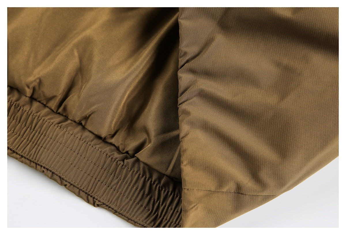 Close-up of the gathered elastic hem on a brown jacket.
