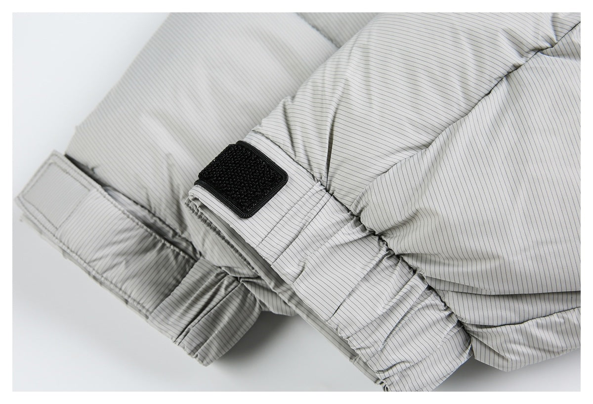 Close-up of a light gray pinstriped garment with a gathered seam and black hook-and-loop adjustment tab.
