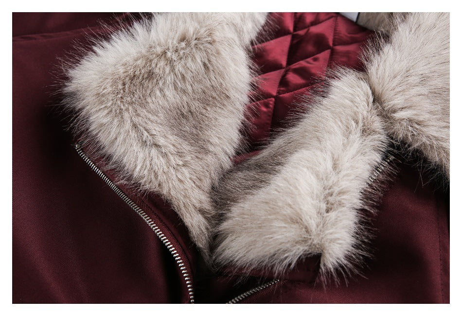 Close-up of the burgundy jacket's pale fur hood trim, quilted lining, and partially open zipper.