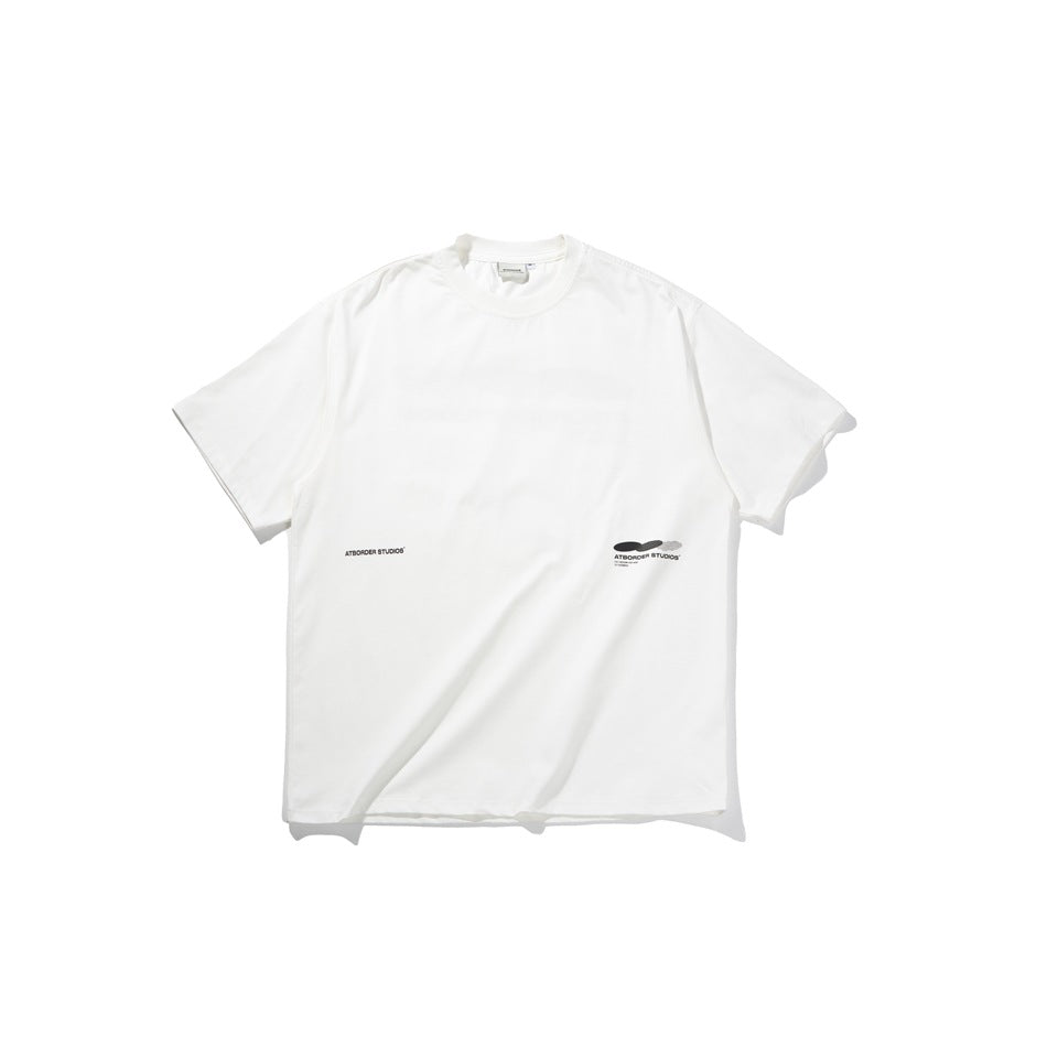 White short-sleeve crew-neck t-shirt flat lay with small black printed text and oval graphic near the lower hem