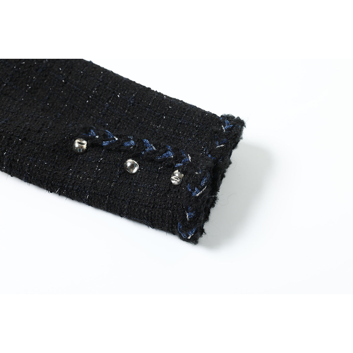 Close-up of a black jacket sleeve cuff with blue embroidered trim and three silver-tone buttons.