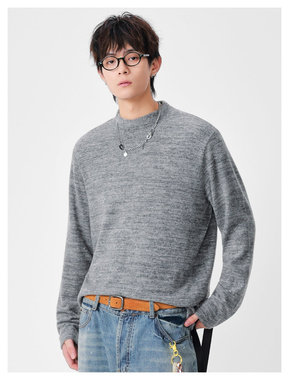 Front view of a model wearing a heather gray mock-neck long-sleeve top with a relaxed fit.