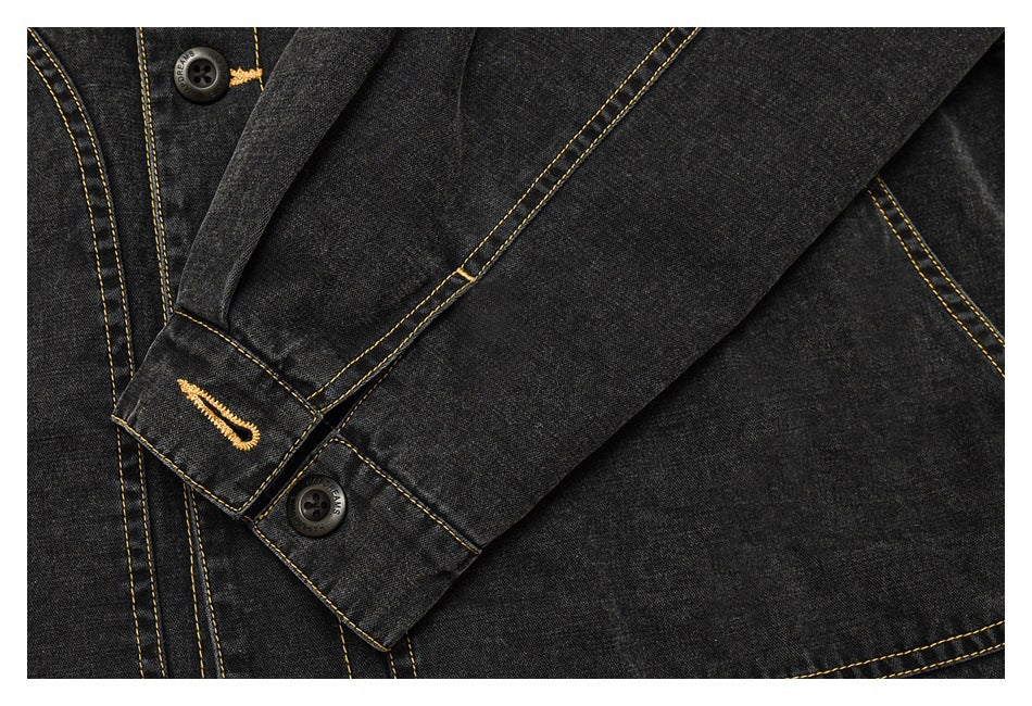 Close-up of a black denim jacket sleeve and cuff with yellow contrast stitching, button, and buttonhole.