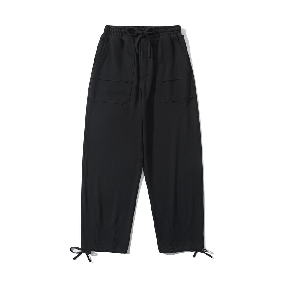 Black drawstring sweatpants, front flat lay, with large front pockets and ankle tie cords
