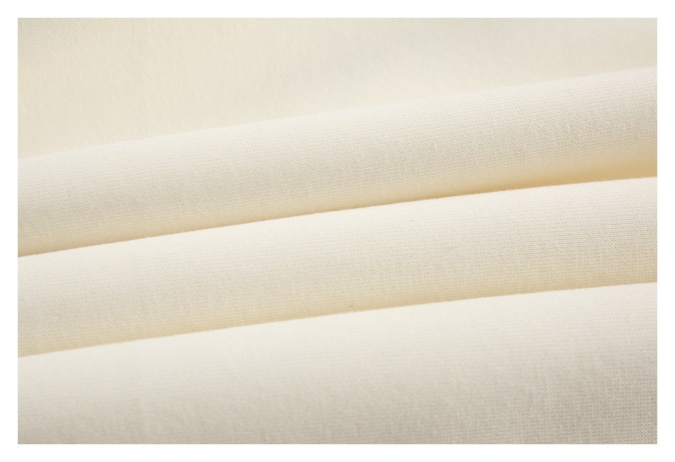 Macro view of cream-colored fabric arranged in soft horizontal folds.