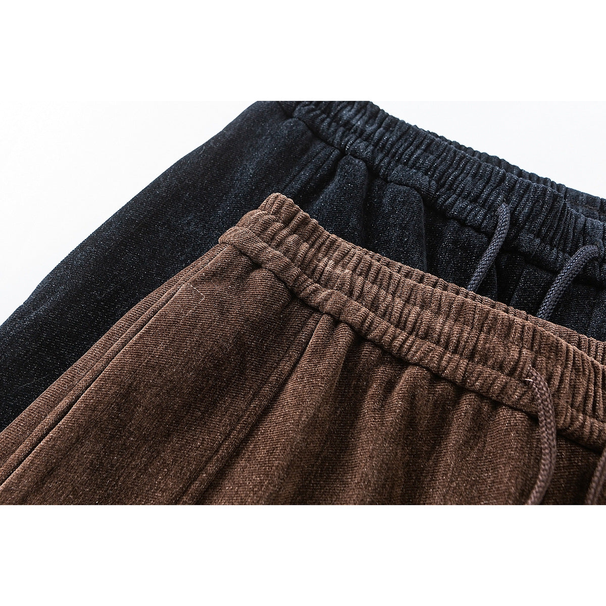Close-up of brown and dark charcoal wide-leg pants, showing elastic drawstring waistbands.