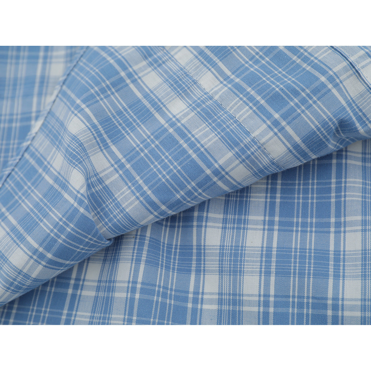 Close-up showing the light blue and white plaid fabric and stitched seam of a shirt.