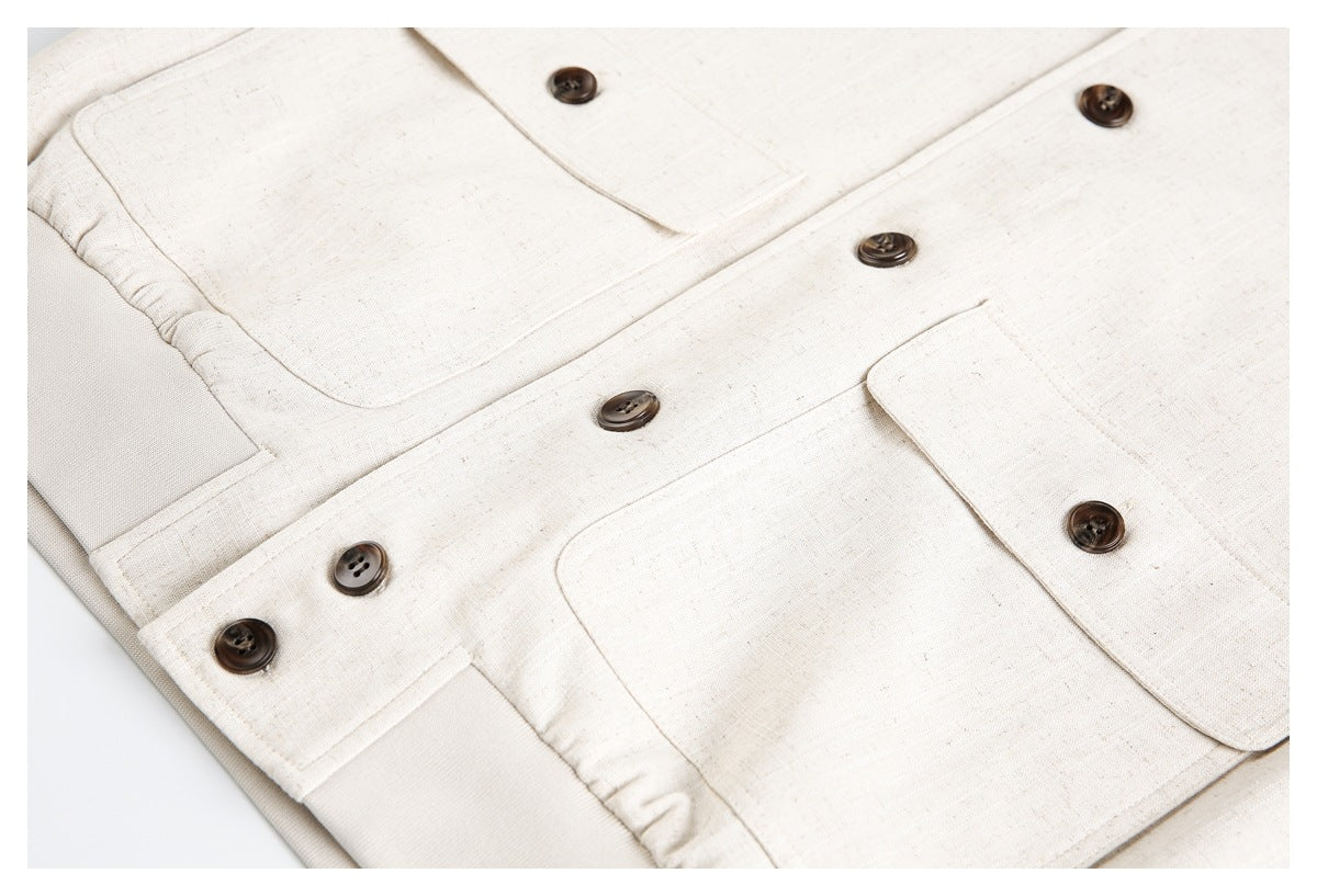 Close-up of a cream jacket front with dark brown buttons and flap pockets.