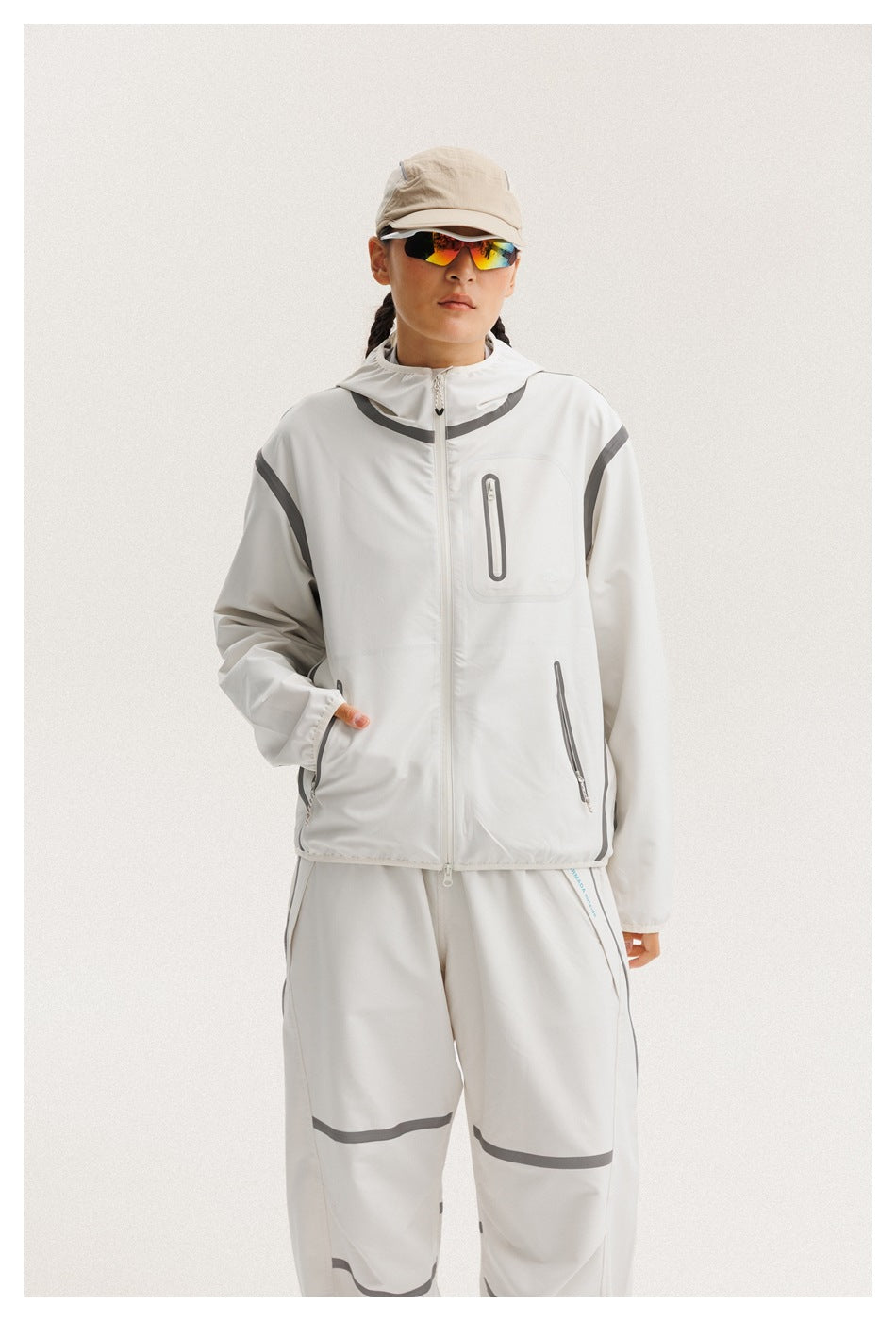 Model in a white zip-front hooded jacket with gray trim and matching pants, shown from the front.