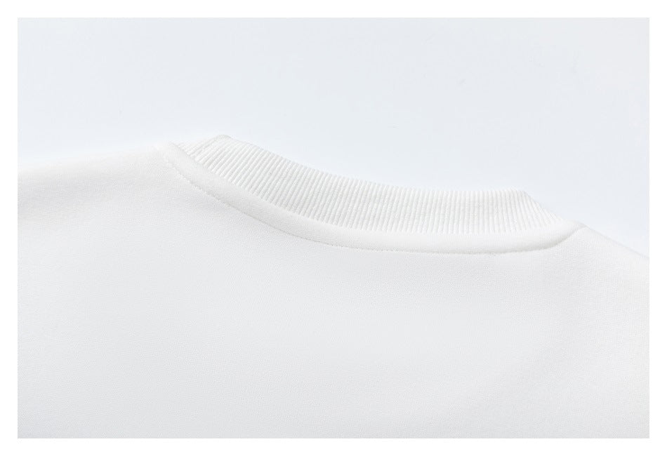 Close-up of the white sweatshirt's ribbed crew neckline and shoulder seam.