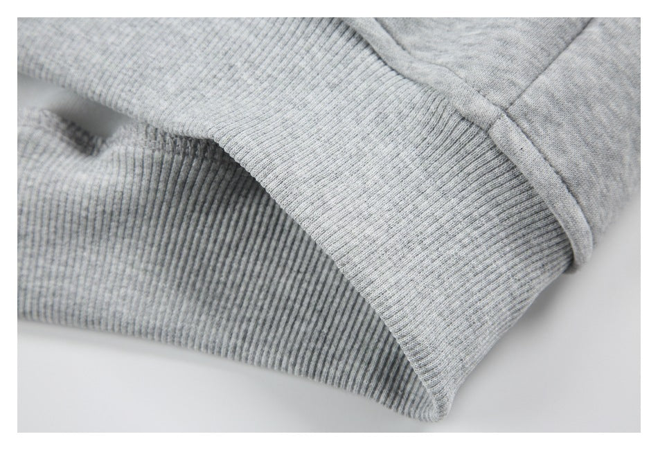 Close-up of the light gray hoodie’s ribbed hem and seam.
