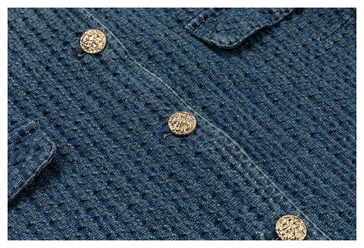 Close-up of the jacket's blue woven texture and several ornate gold buttons.