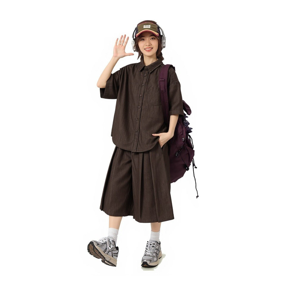 Model wearing a dark brown short-sleeve button-up shirt and matching wide cropped pants.
