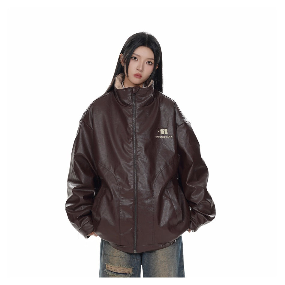 Model wearing a reddish brown zip-up faux-leather-look jacket with stand collar and ripped light-wash jeans, front view