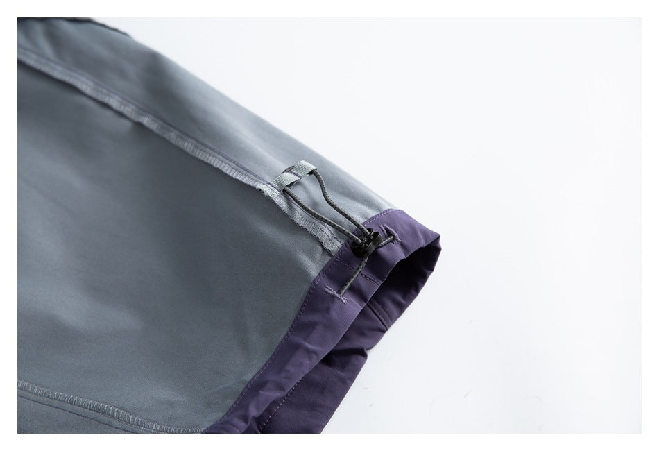 Close-up of gray garment fabric with a purple edge and an adjustable cord lock.