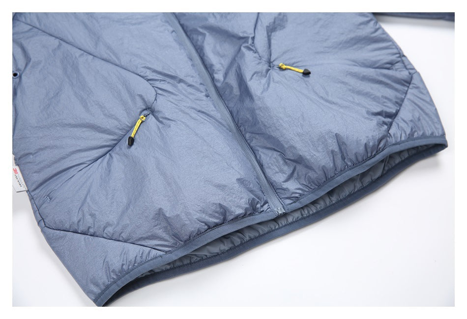 Close view of the jacket's lower front, showing the zipper, angled pockets, yellow pulls and finished hem.