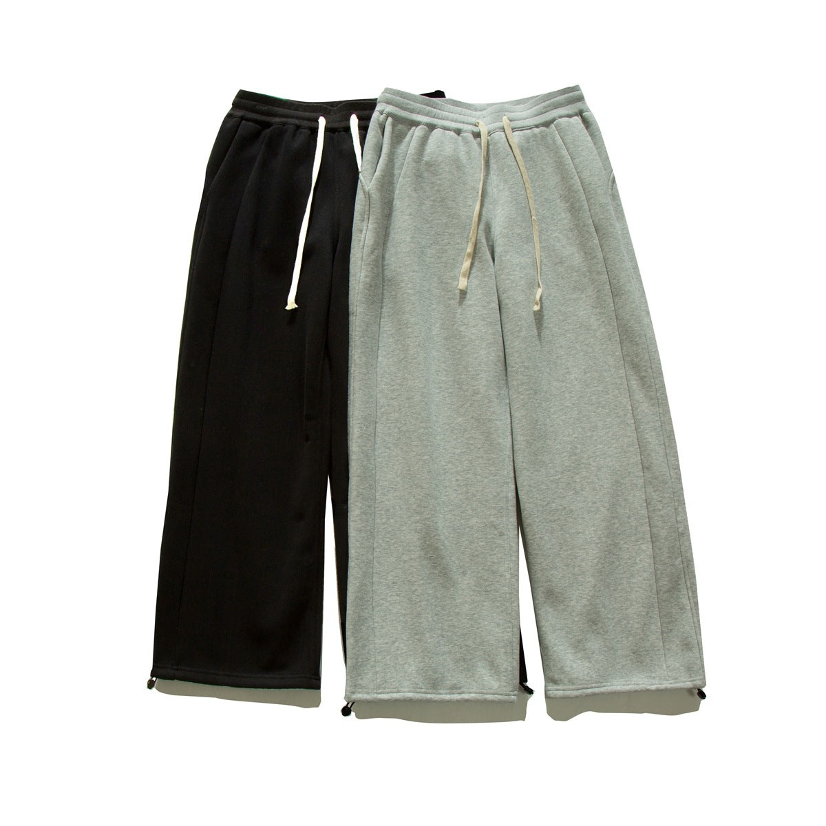 Front view of wide-leg drawstring sweatpants in black and light gray, shown flat with adjustable ankle toggles.