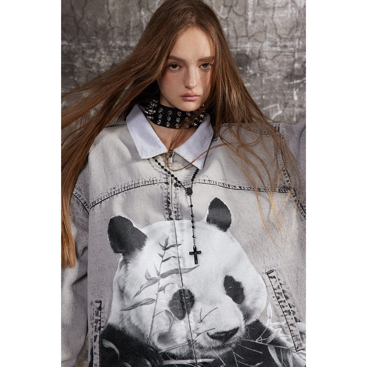Close-up of a model wearing a pale gray jacket with a large panda graphic and pointed collar.