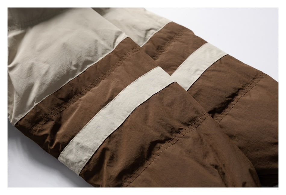 Close-up of brown and cream color-blocked garment panels with stitched seams.