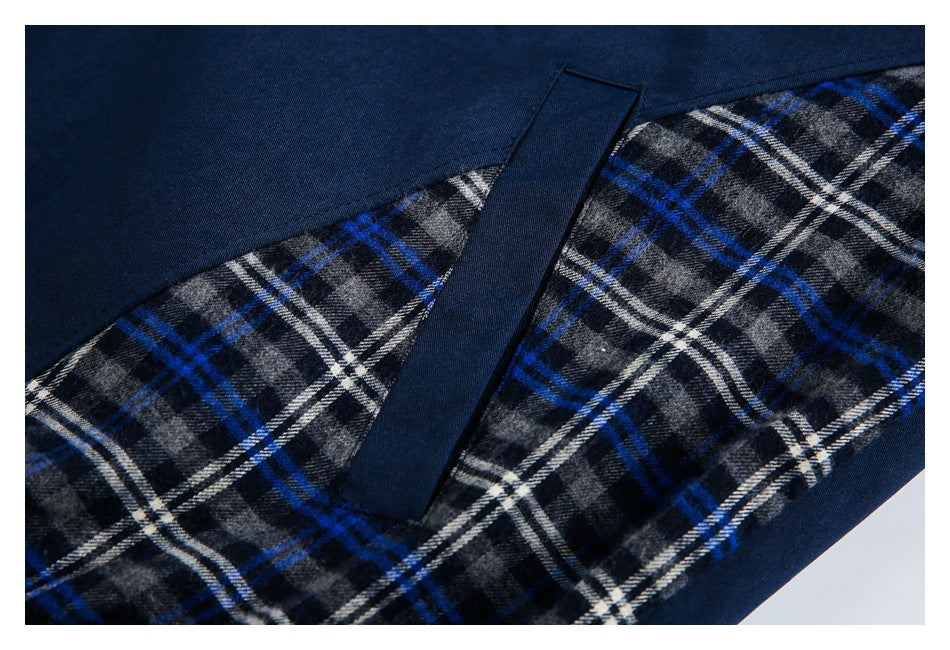Close-up of the jacket's blue, black and white plaid side panel beside navy trim.