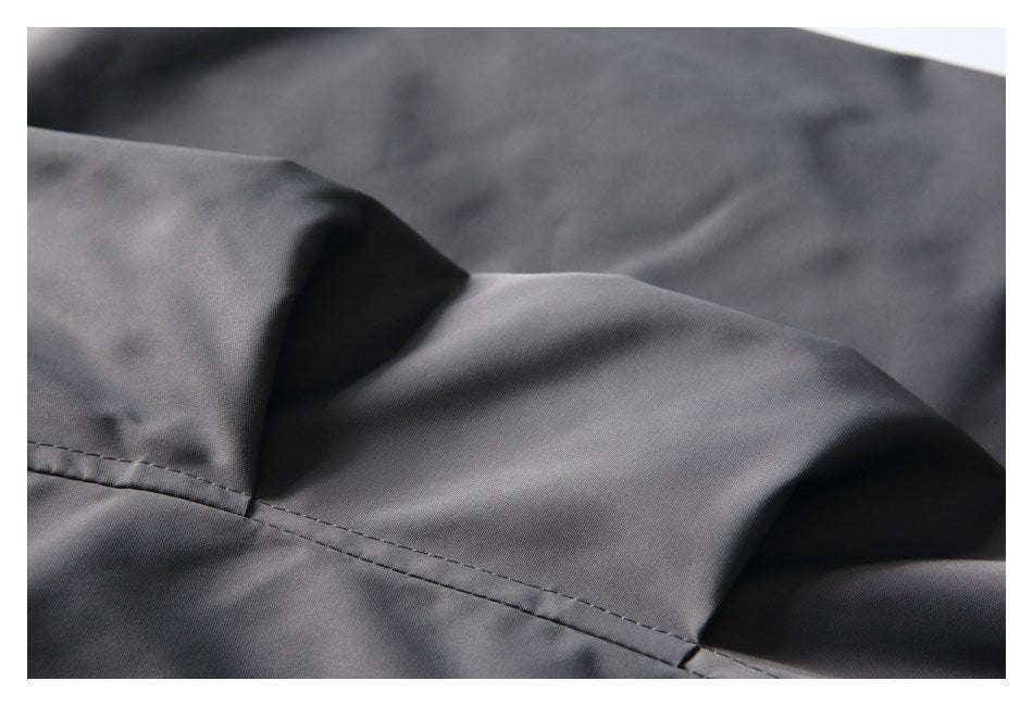 Close-up of a stitched seam across smooth gray garment fabric.