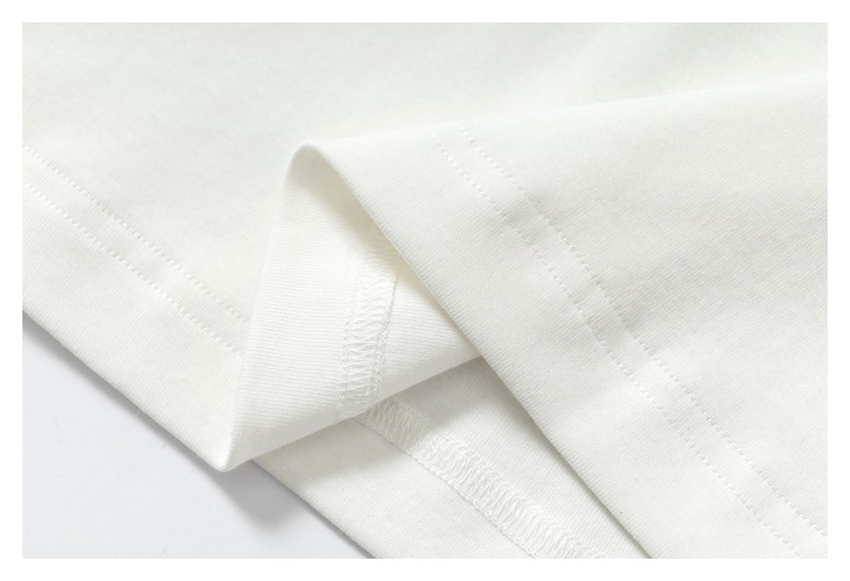 Close-up of folded white fabric showing stitching and an overlocked seam.