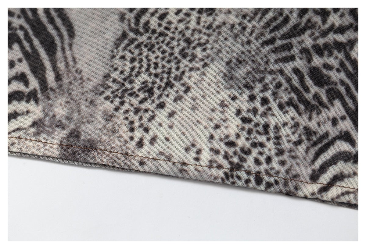 Close-up of the stitched hem on gray-brown animal-print fabric.